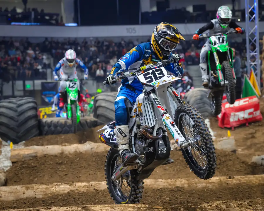 Two riders side by side in the air over the course